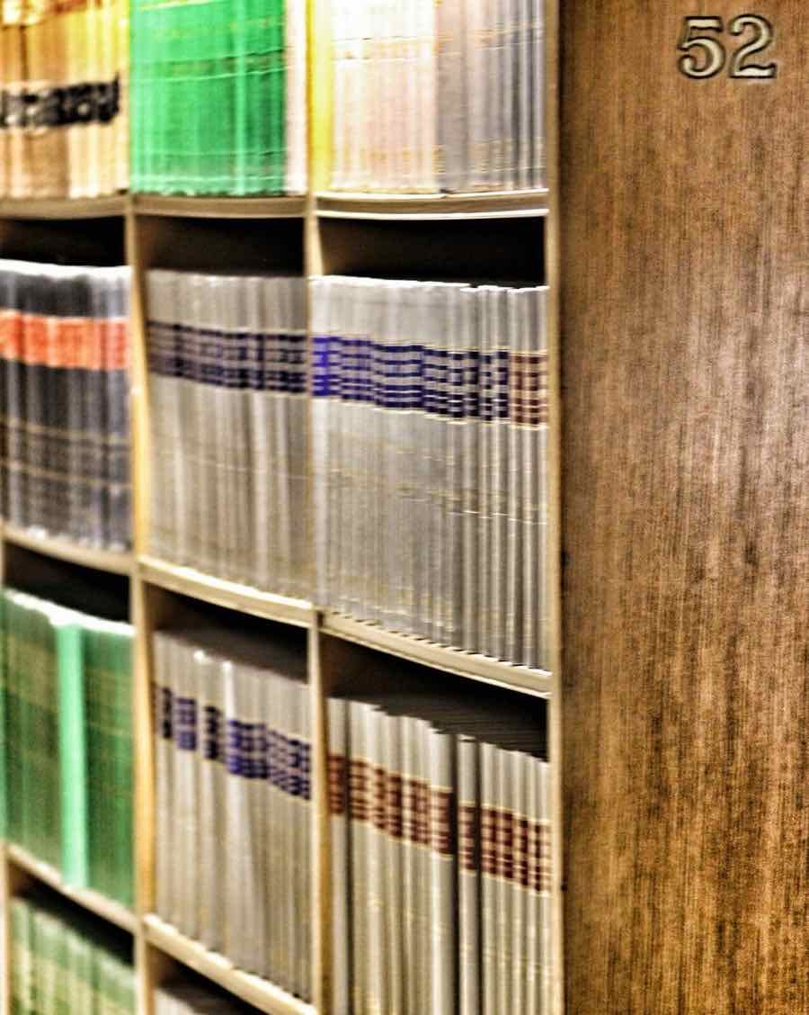 Gesetzbücher in einem Regal aus Holz.
